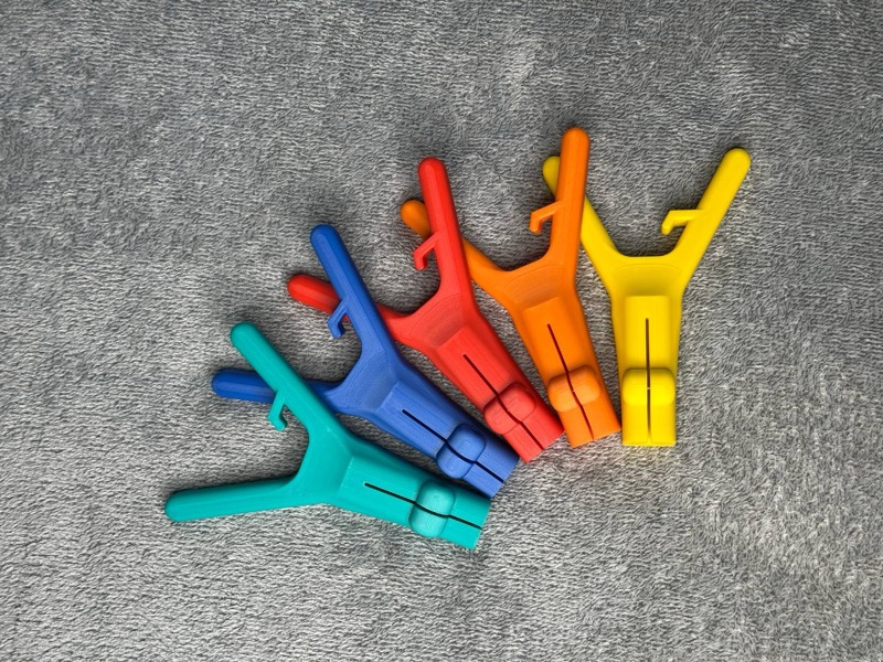 Fünf Geocaching-Angeladapter in Türkis, Blau, Rot, Orange und Gelb, fächerförmig angeordnet